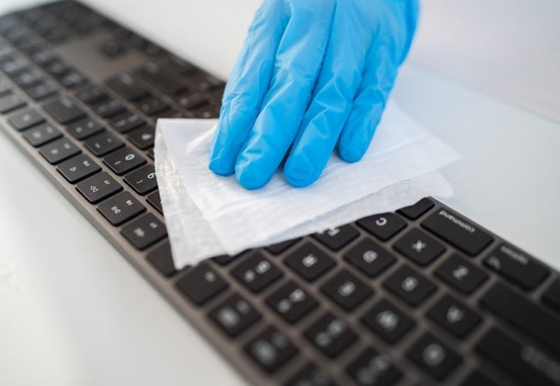 cleaning a keyboard with disinfecting wipes